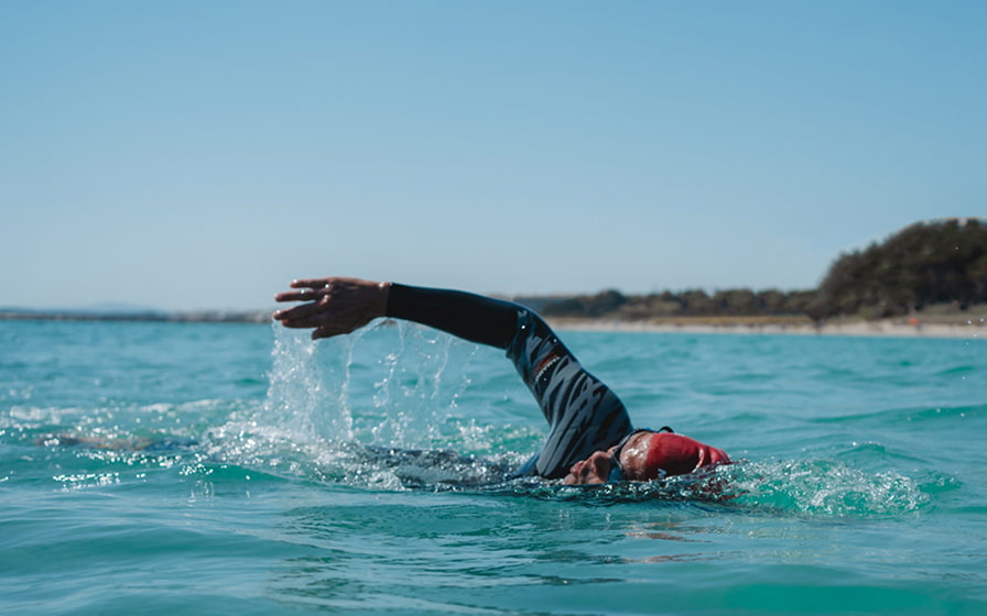 Deportista nadando en Playa de Muro